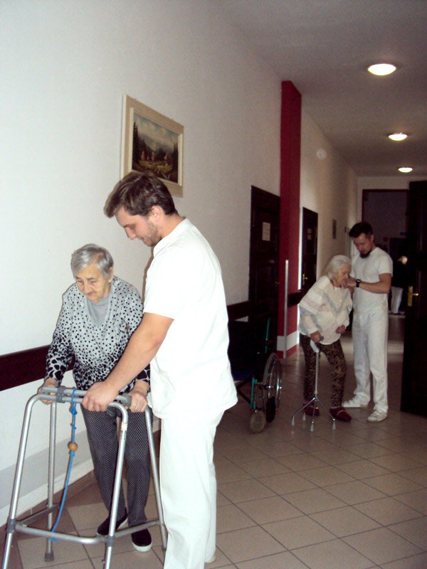 rehabilitanci przy pacjentkach pomagają im poruszać się przy użyciu balkoników